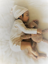 Load image into Gallery viewer, Sleeping baby wearing knotted beanie hat holding knit stuffed bear Organic Pima Cotton Baby Long Sleeve single picture of flat ecowhite white Bodysuit GOTS certified snap buttons handmade in Peru for Pan American Apparel in Ecowhite and soft pink for newborn 0 to 3 months 3 to 6 months 6 to 9 months 9 to 12 months 12 to 18 months
