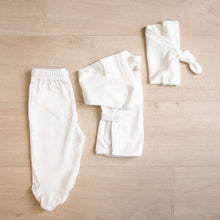 Load image into Gallery viewer, White organic cotton baby outfit. Hello baby organic pima cotton gift set. Body suit long sleeve wrap top kimono footed pants knotted hat that goes in Organic Pima Cotton Baby gift box set bundle present baby shower hat kimono side snap top footed pants. Long Sleeve Bodysuit GOTS certified snap buttons handmade in Peru for Pan American Apparel in Ecowhite white newborn 0 to 3 months.
